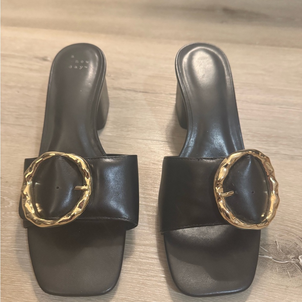 Black low heel sandals with gold ring